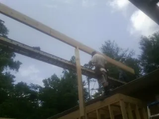 Carpenter setting a ridge beam over a new addition frame — Ice Dam Removal by Roofing Brothers in Hermitage