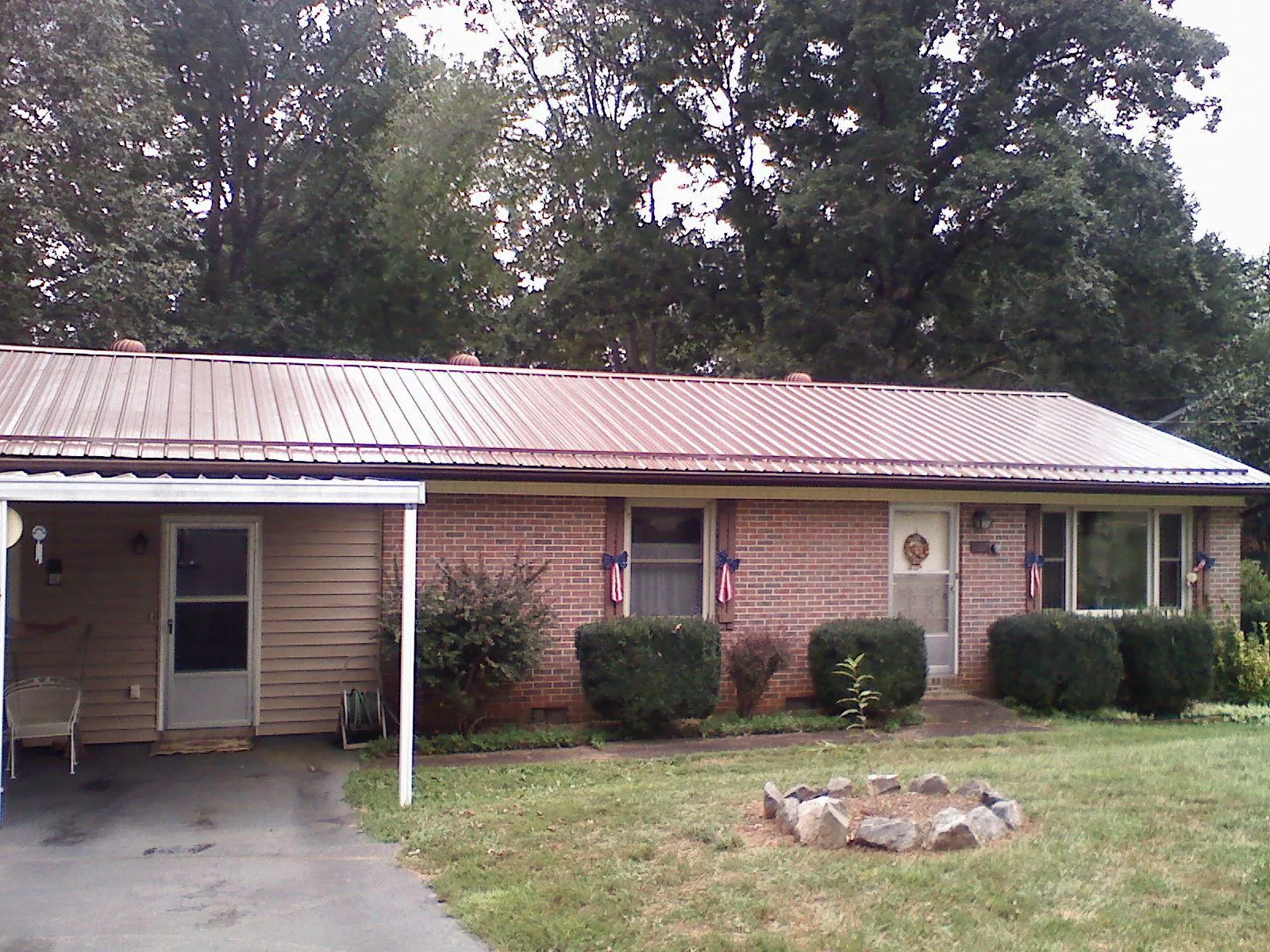 Bronze metal roof and carport on a brick ranch home — Roof Repair work by our crew in Hermitage